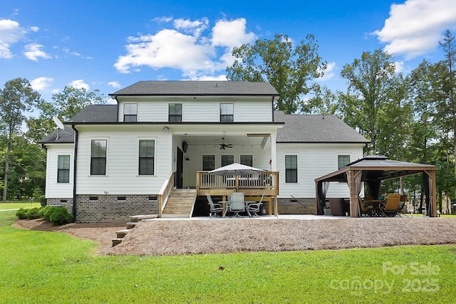 rear view of property featuring a gazebo, ceiling fan, and a yard