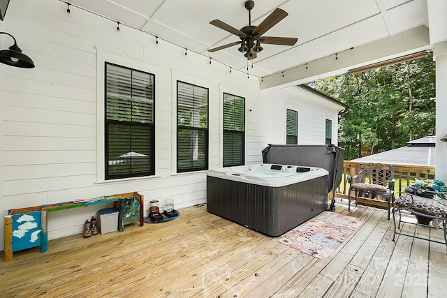 wooden deck featuring ceiling fan and a hot tub