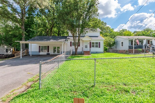 view of front of property with a carport and a front lawn