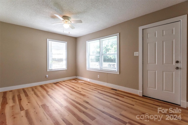 foyer featuring a textured ceiling, ceiling fan, and light hardwood / wood-style flooring