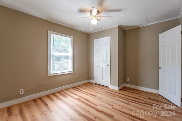 unfurnished bedroom featuring ceiling fan, crown molding, and light hardwood / wood-style flooring