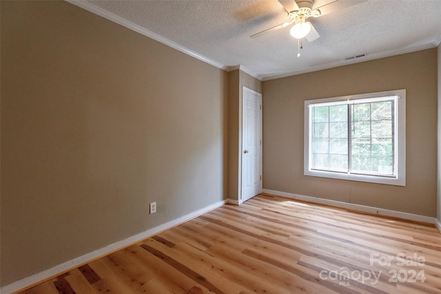 unfurnished room featuring light hardwood / wood-style floors, a textured ceiling, ornamental molding, and ceiling fan