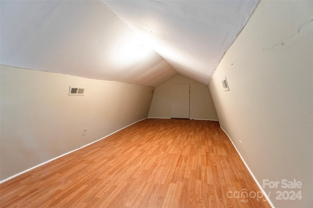 bonus room with lofted ceiling and light hardwood / wood-style floors