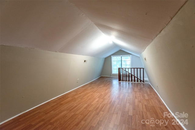 bonus room with vaulted ceiling and light hardwood / wood-style floors