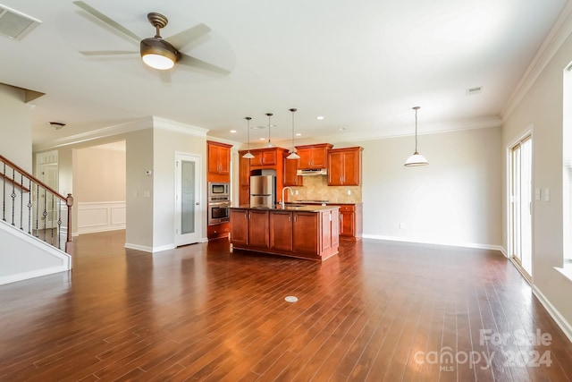 kitchen with appliances with stainless steel finishes, sink, hanging light fixtures, and a center island with sink