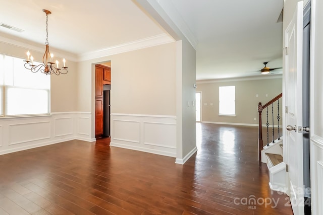 unfurnished room with ceiling fan with notable chandelier, ornamental molding, and dark hardwood / wood-style floors