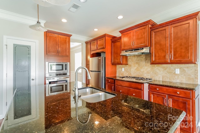 kitchen with sink, crown molding, dark stone countertops, appliances with stainless steel finishes, and backsplash