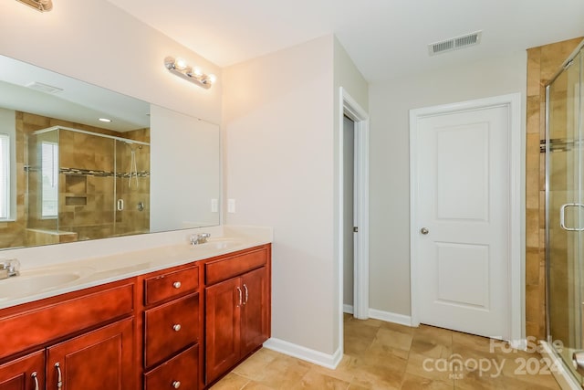 bathroom with tile patterned floors, vanity, and a shower with door