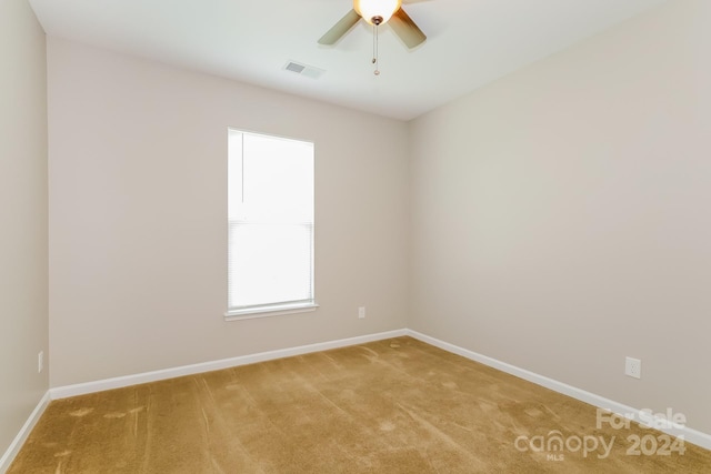 empty room featuring light colored carpet and ceiling fan