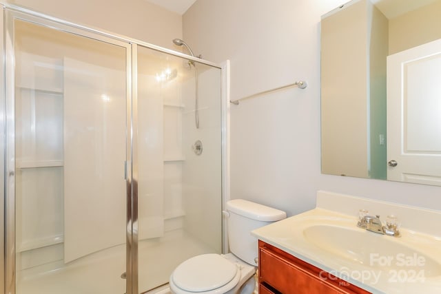 bathroom with toilet, vanity, and walk in shower