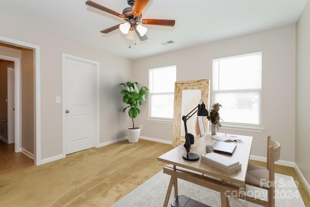 carpeted home office featuring ceiling fan