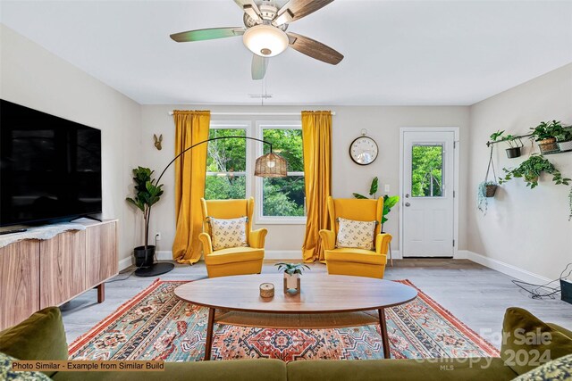 living room with light wood-type flooring and ceiling fan