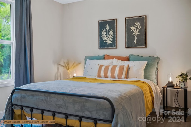 bedroom with hardwood / wood-style flooring and multiple windows