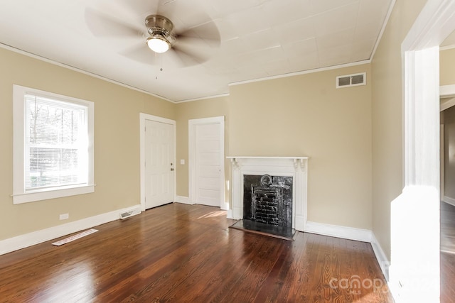 unfurnished living room with ceiling fan, dark wood-type flooring, ornamental molding, and a fireplace