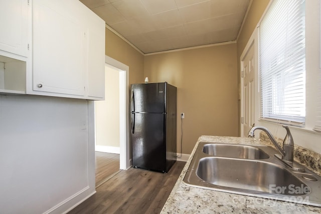 kitchen with sink, white cabinetry, ornamental molding, black refrigerator, and dark hardwood / wood-style flooring