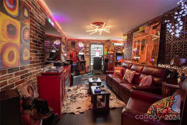 living room featuring brick wall, ceiling fan, and wood-type flooring