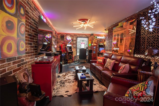 living room with hardwood / wood-style floors and brick wall