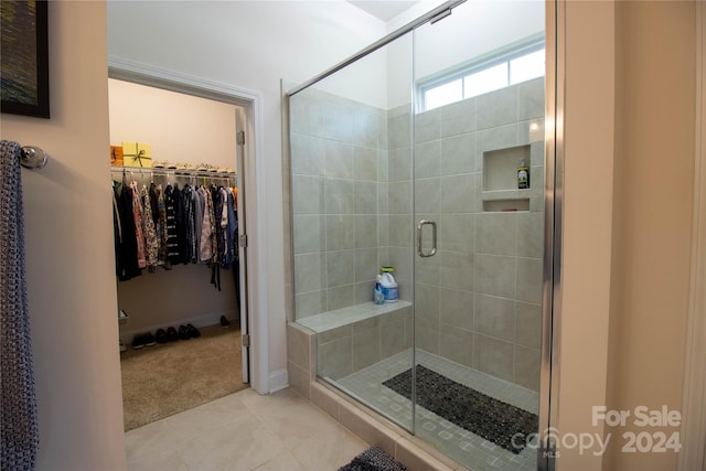 bathroom with tile patterned flooring and a shower with shower door