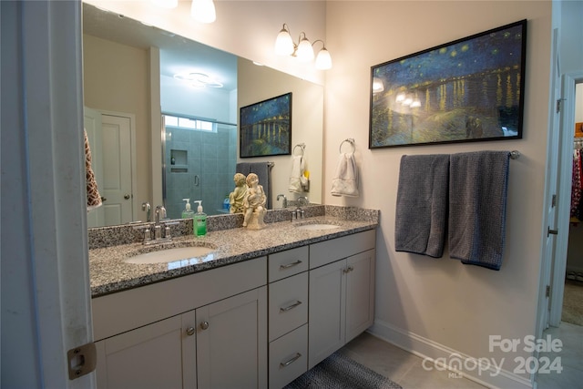 bathroom with tile patterned floors, a tile shower, and vanity