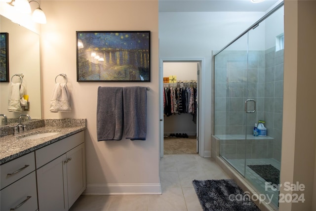 bathroom featuring tile patterned flooring, an enclosed shower, and vanity