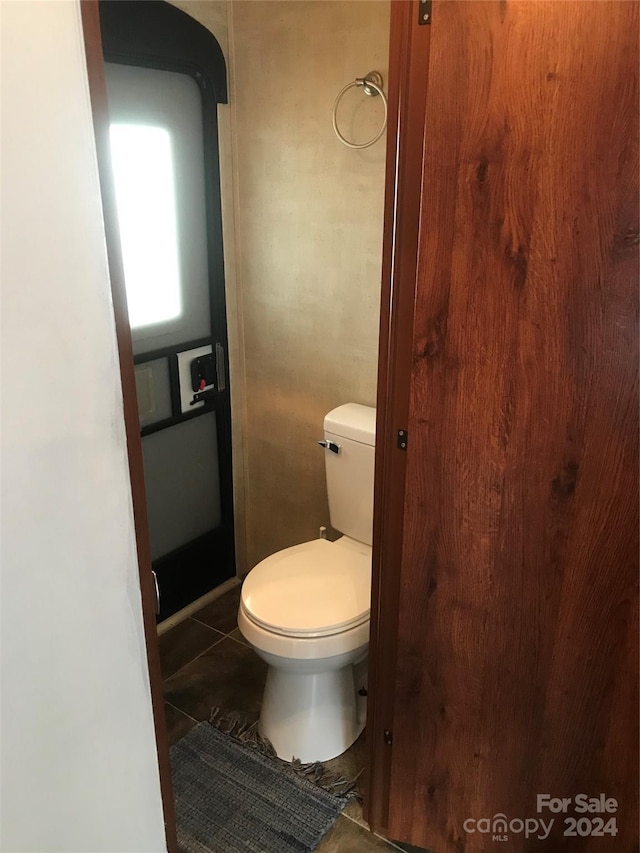 bathroom featuring toilet and tile patterned flooring