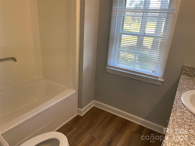 full bathroom with hardwood / wood-style floors, vanity, toilet, and tub / shower combination