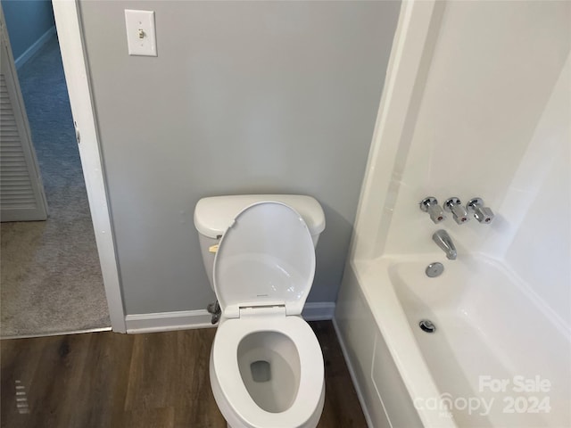 bathroom with a bath, wood-type flooring, and toilet