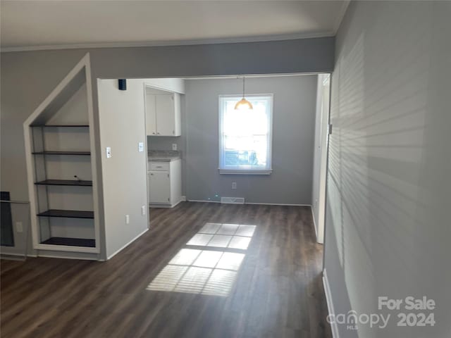 interior space with dark hardwood / wood-style flooring and ornamental molding