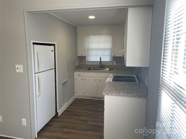 kitchen featuring white refrigerator, white cabinetry, sink, and a wealth of natural light