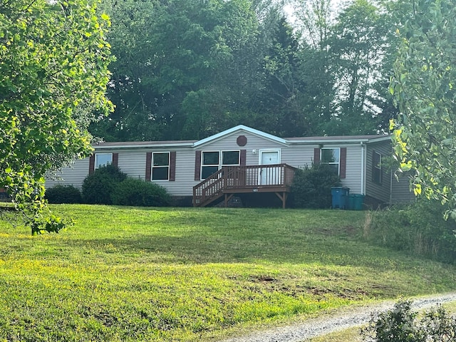 manufactured / mobile home with a front yard and a wooden deck