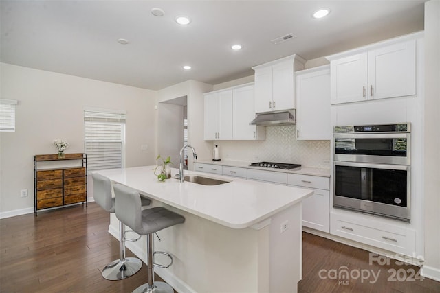 kitchen with a center island with sink, sink, and white cabinetry