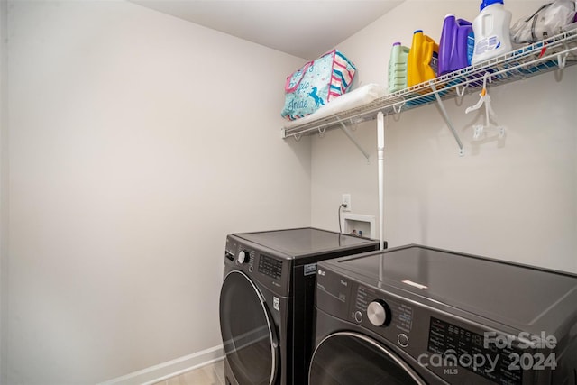 laundry room with wood-type flooring and separate washer and dryer