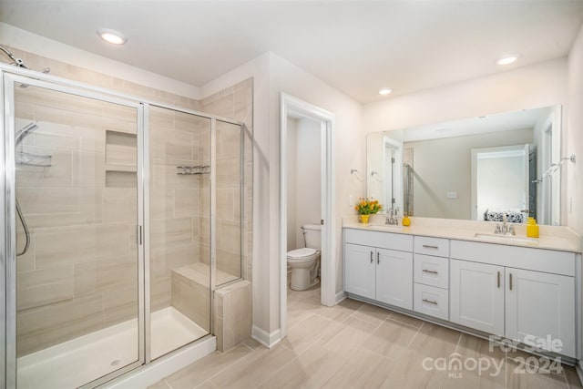 bathroom featuring vanity, toilet, and walk in shower