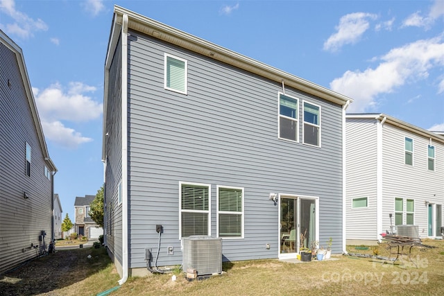 rear view of house featuring a yard and central air condition unit