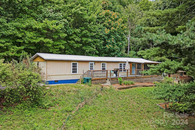 view of front of home with a deck and a front yard