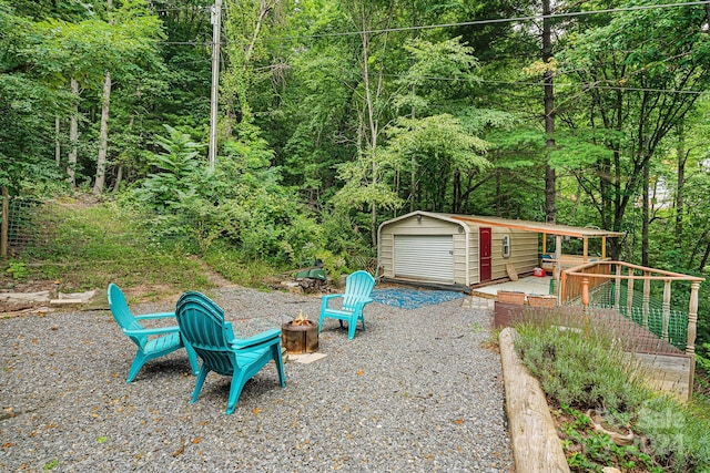 view of yard with a fire pit, a garage, and an outbuilding