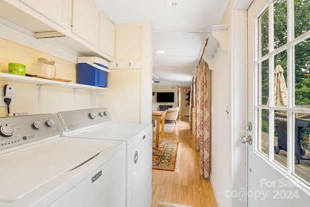 laundry area with cabinets, separate washer and dryer, and light wood-type flooring