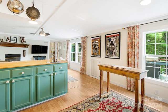 kitchen with ceiling fan, butcher block counters, light hardwood / wood-style flooring, and green cabinets