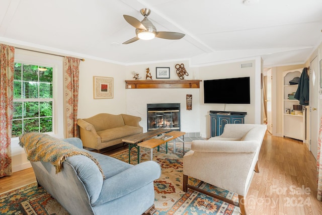 living room with ceiling fan, vaulted ceiling, light hardwood / wood-style flooring, and built in features