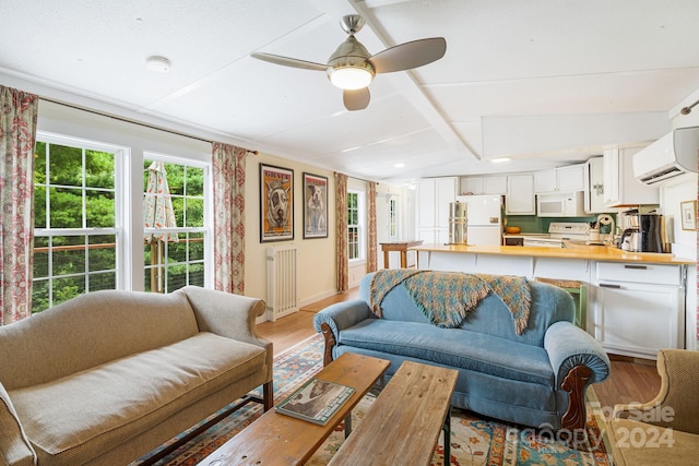 living room featuring ceiling fan, vaulted ceiling, light hardwood / wood-style floors, and a wall mounted air conditioner