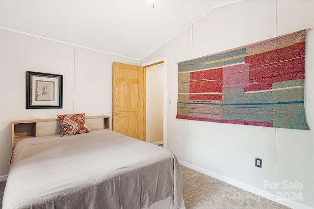 carpeted bedroom featuring ornamental molding and lofted ceiling