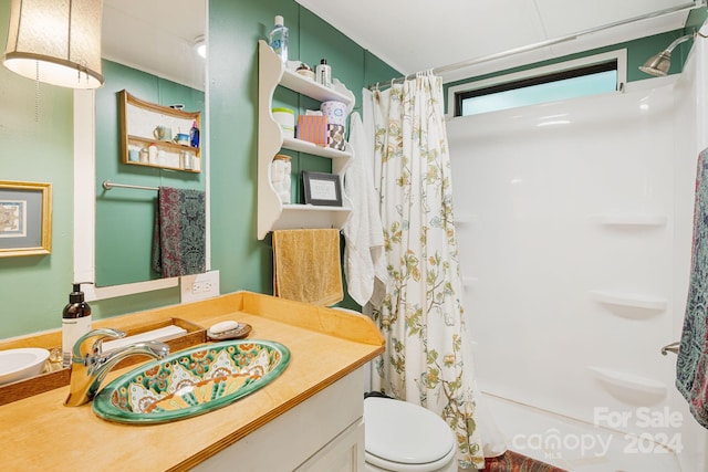 bathroom with toilet, vanity, and curtained shower