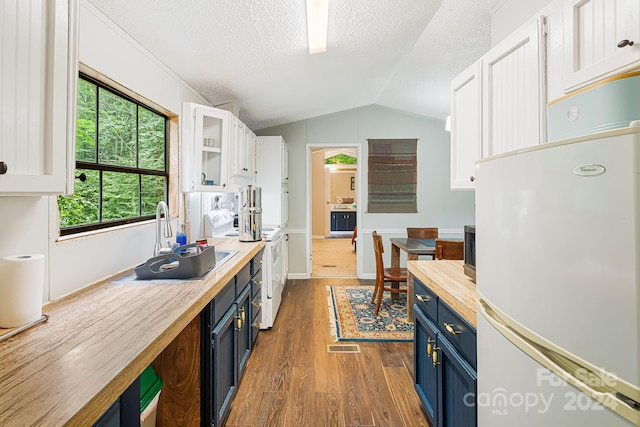 kitchen featuring white cabinets, wood-type flooring, white appliances, vaulted ceiling, and blue cabinets