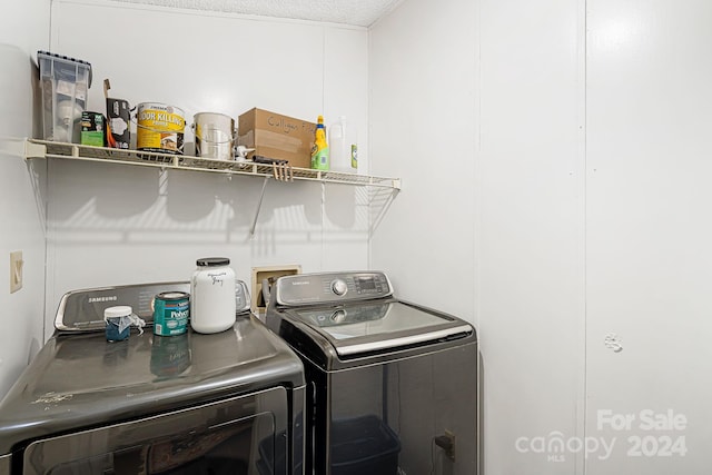 laundry area featuring washer and clothes dryer and a textured ceiling