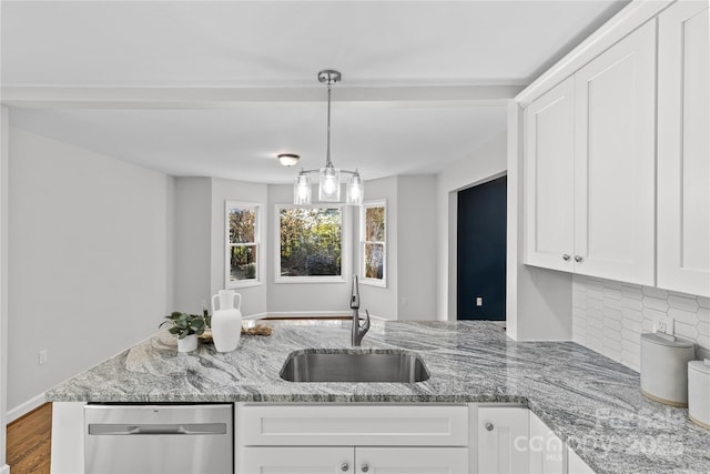 kitchen featuring white cabinetry, sink, stainless steel dishwasher, and light stone counters