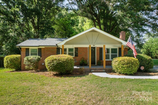 ranch-style home with a porch and a front yard