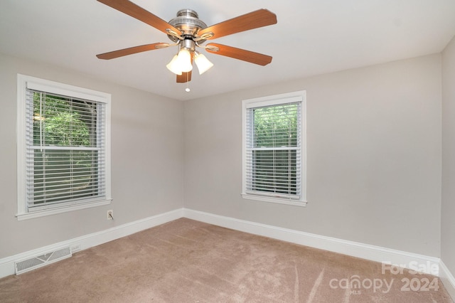 unfurnished room featuring baseboards, visible vents, ceiling fan, and light colored carpet