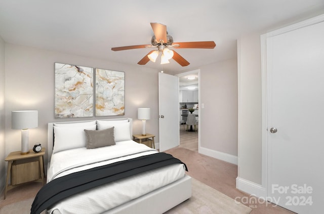 bedroom featuring baseboards, a ceiling fan, and light colored carpet