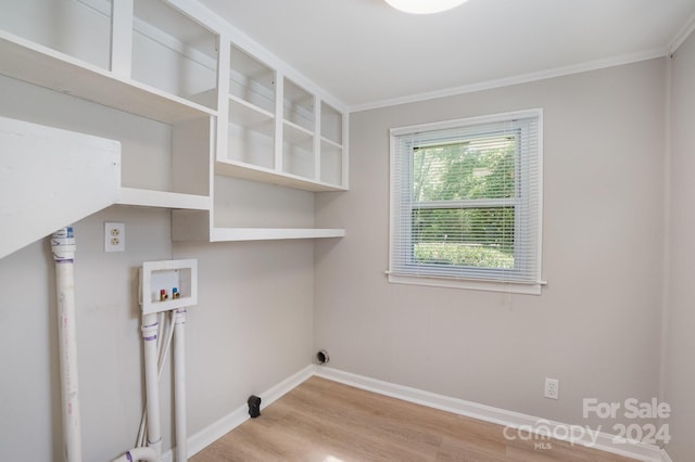 clothes washing area featuring hookup for a washing machine, ornamental molding, wood finished floors, laundry area, and baseboards