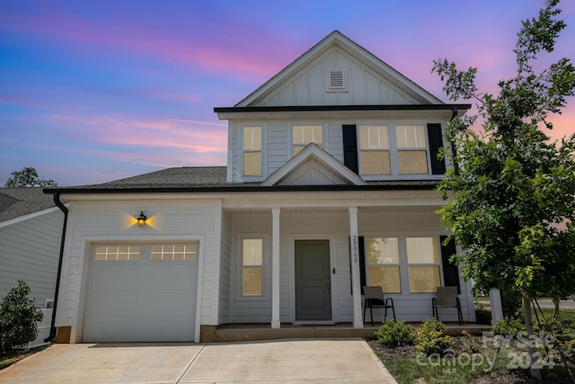 view of front of house featuring a garage, driveway, a shingled roof, a porch, and board and batten siding